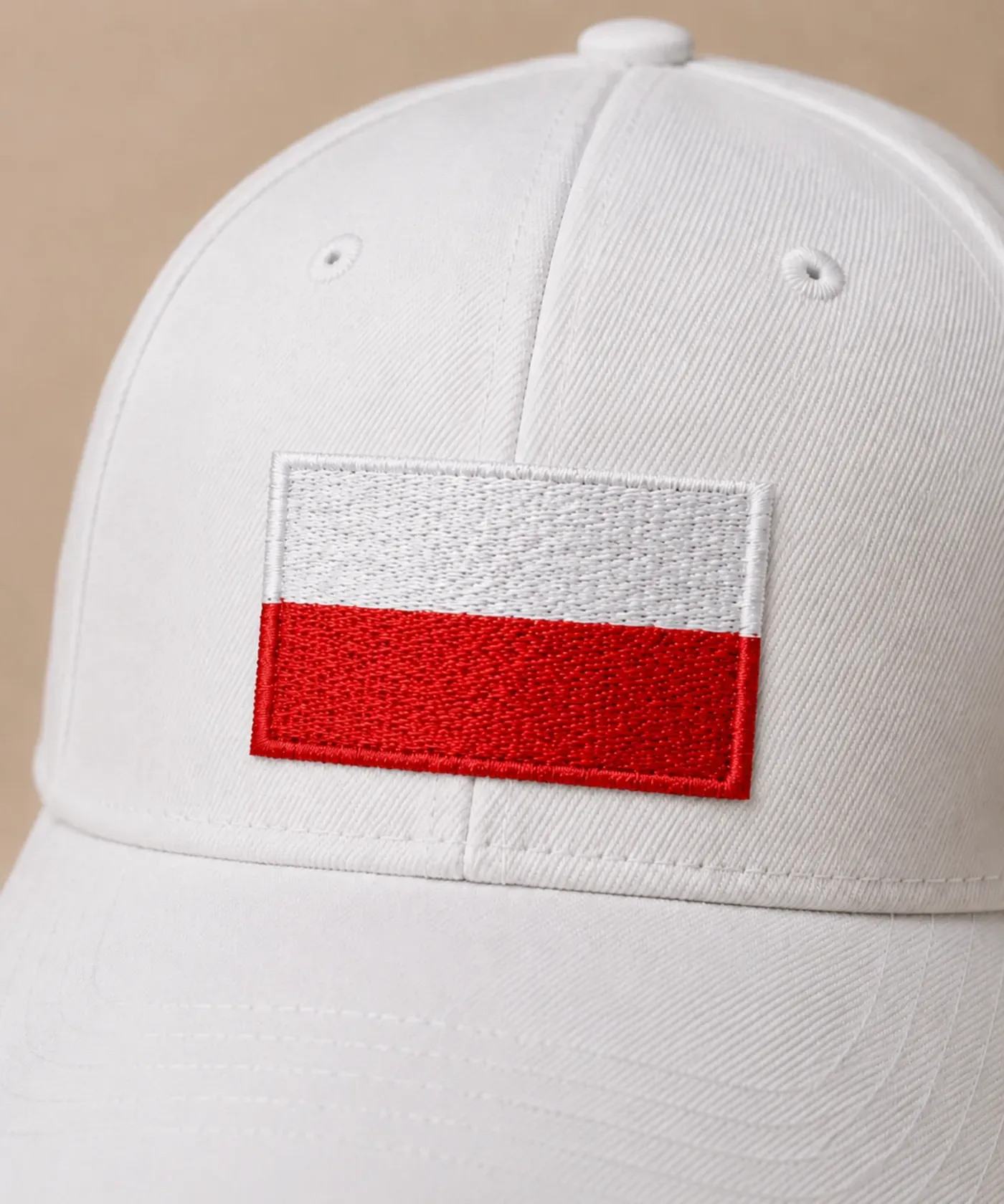 Biała czapka z daszkiem z haftowanym logo wykonanym metodą haftu komputerowego detal