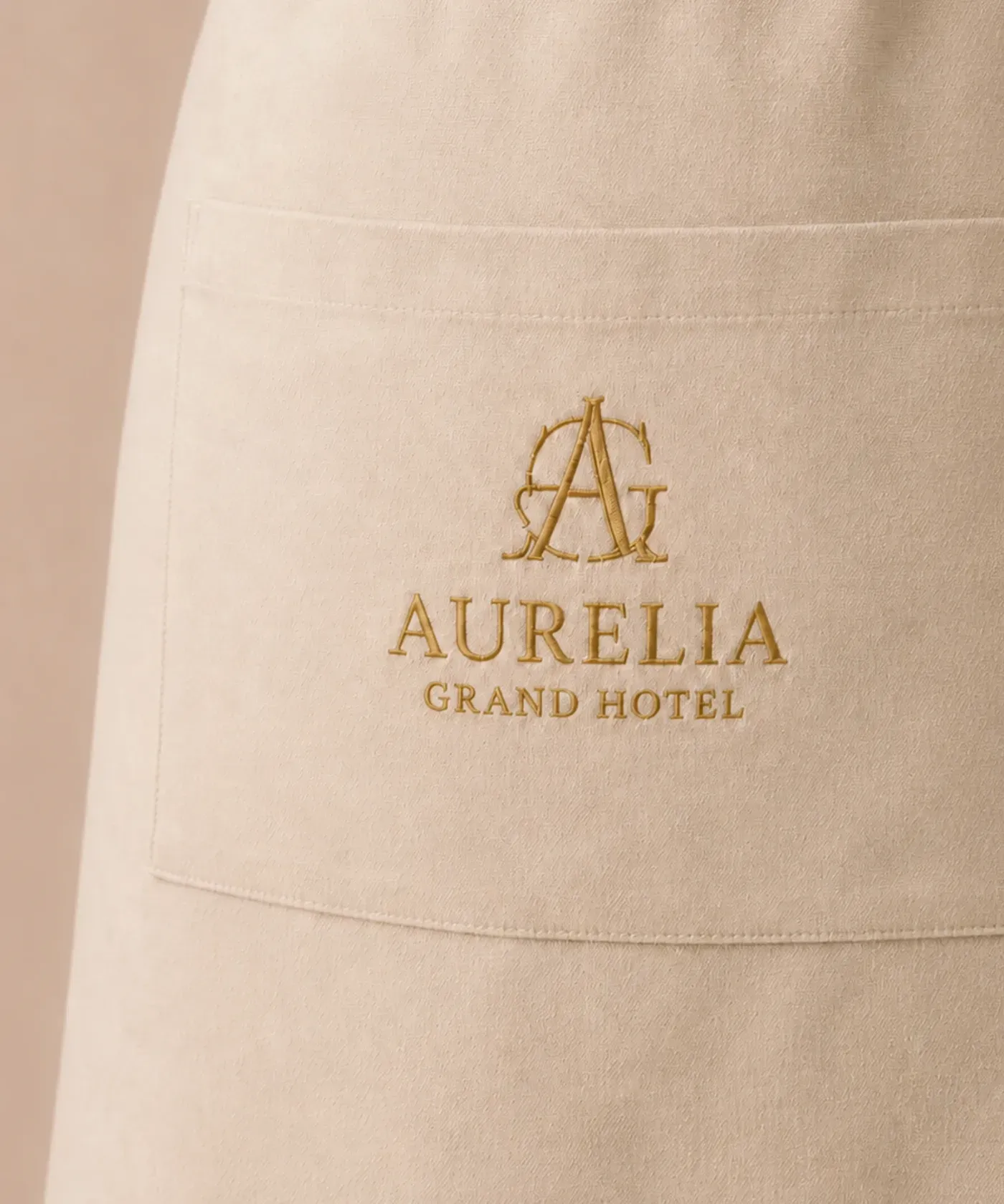 Długi fartuch gastronomiczny z tkaniny canvas z kieszenią i haftowanym logo hotelu lub restauracji