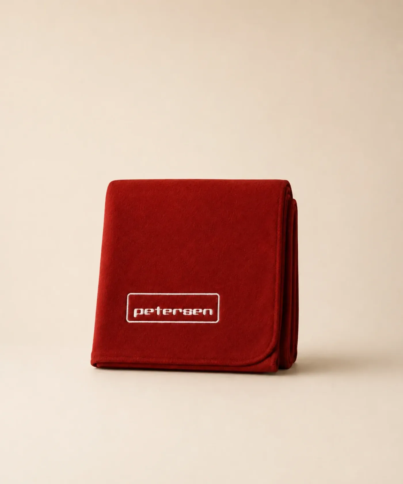 Czerwony koc polarowy z haftowanym logo firmy 